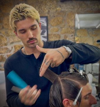 Máximo Zabaleta, profesor de barbería, con un cliente