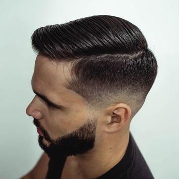 Corte de caballero con degradado bajo, raya marcada y barba perfilada